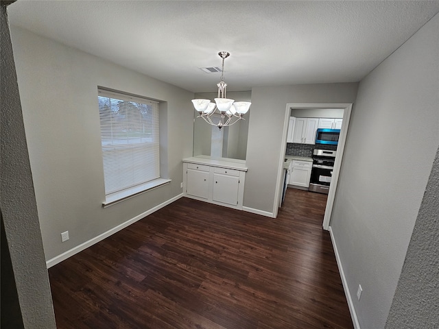 unfurnished dining area with dark wood-type flooring and a chandelier