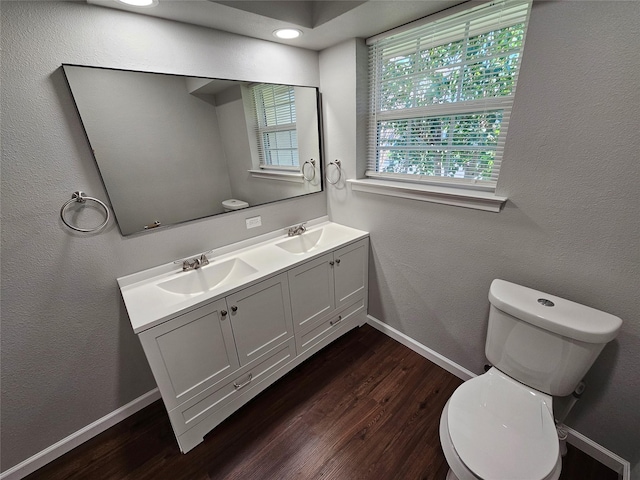714 Austrian Rd, Grand Prairie, TX 75050 - bathroom with toilet, baseboards, wood finished floors, double vanity, and a textured wall