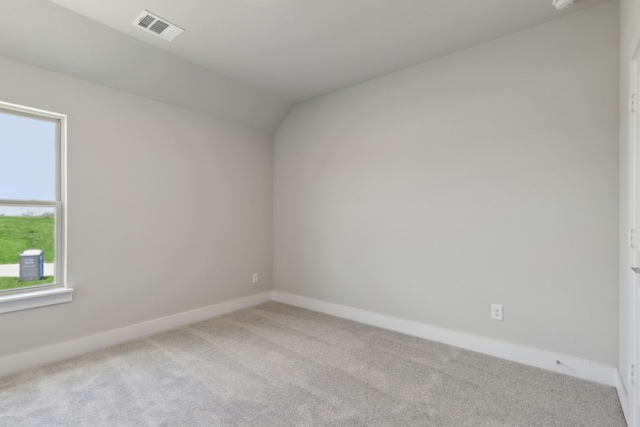 carpeted empty room with lofted ceiling