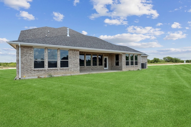 rear view of property with central AC and a yard