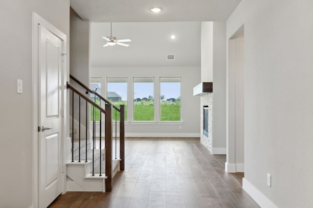 interior space featuring ceiling fan, wood-type flooring, and a fireplace