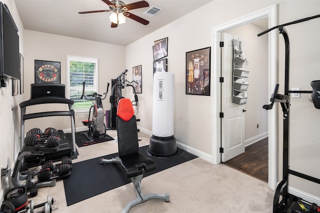 exercise area featuring dark colored carpet and ceiling fan