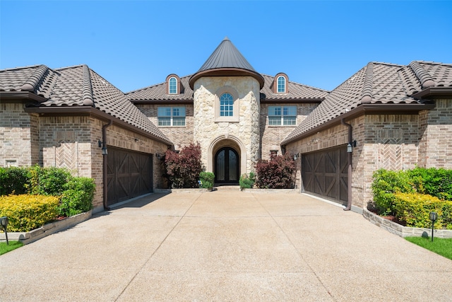 french country inspired facade with a garage and french doors