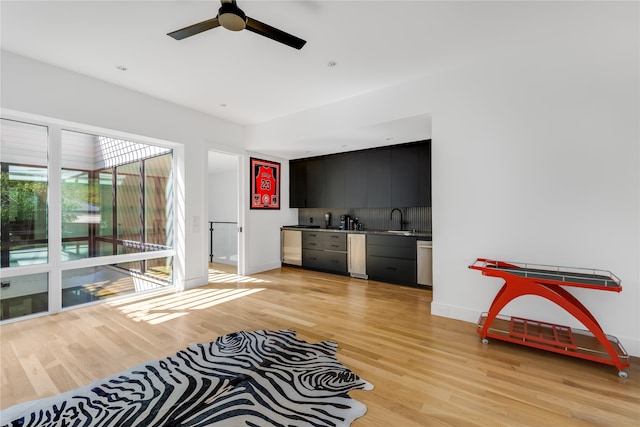 living room featuring light hardwood / wood-style flooring, ceiling fan, and sink