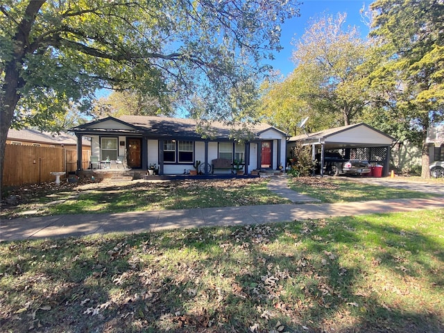 ranch-style home with covered porch, a carport, and a front yard