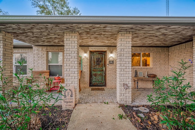 view of exterior entry featuring covered porch