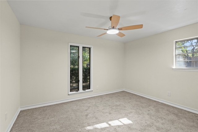 spare room featuring light colored carpet and ceiling fan