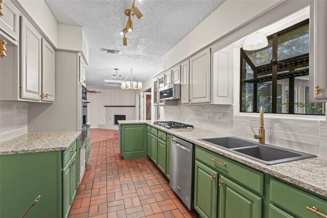 kitchen with sink, appliances with stainless steel finishes, decorative light fixtures, white cabinets, and green cabinetry