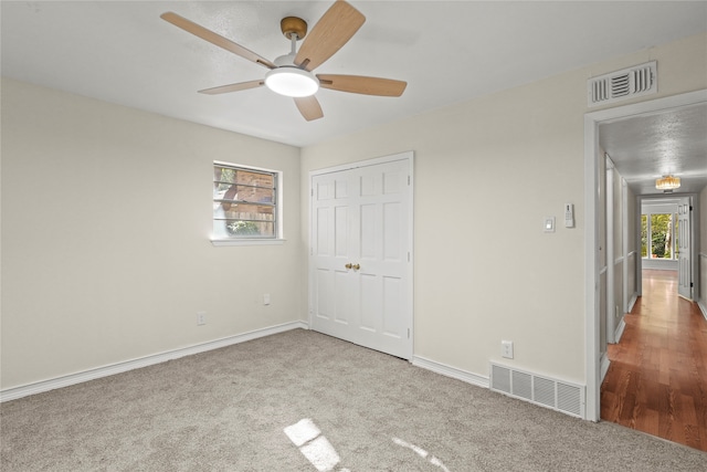 unfurnished bedroom featuring ceiling fan, carpet, and a closet