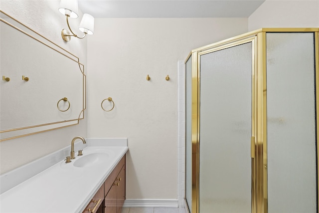 bathroom featuring a shower with door, vanity, and tile patterned floors