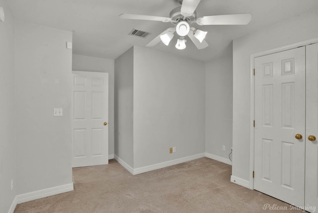 unfurnished bedroom featuring ceiling fan, light carpet, and a closet