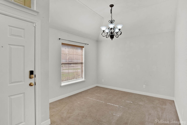 empty room featuring light carpet, an inviting chandelier, and vaulted ceiling