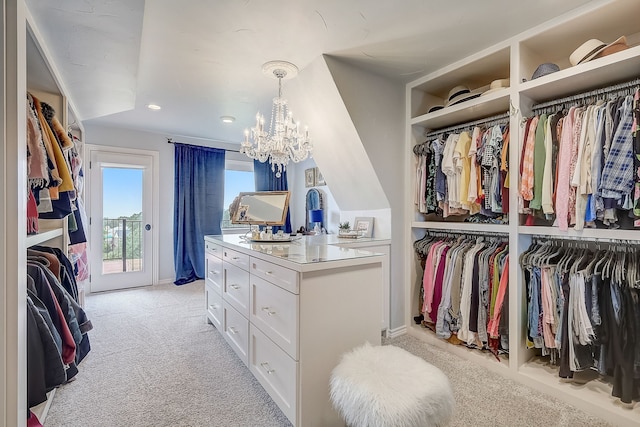 spacious closet with light colored carpet and a notable chandelier