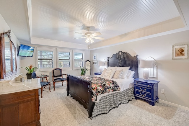 bedroom with ceiling fan, a raised ceiling, and light carpet