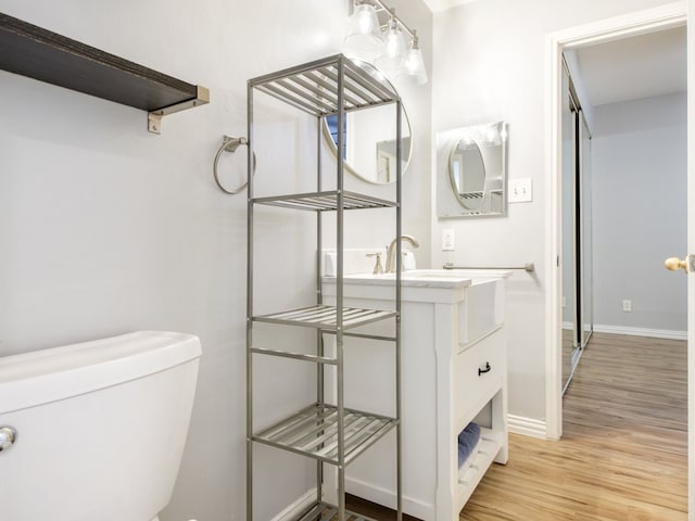 bathroom with hardwood / wood-style floors, vanity, and toilet