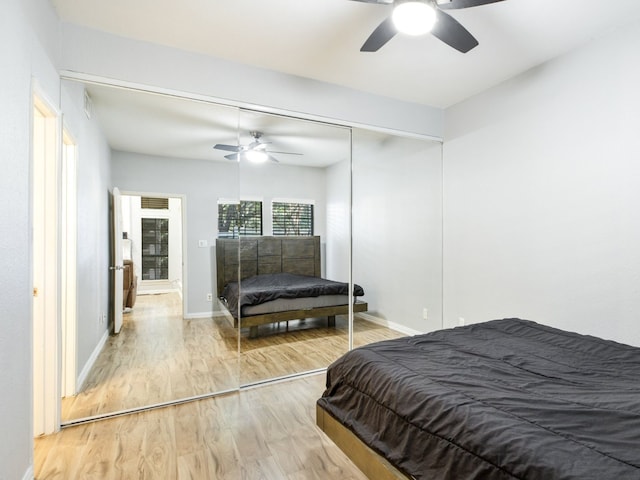 bedroom with ceiling fan, wood-type flooring, and a closet