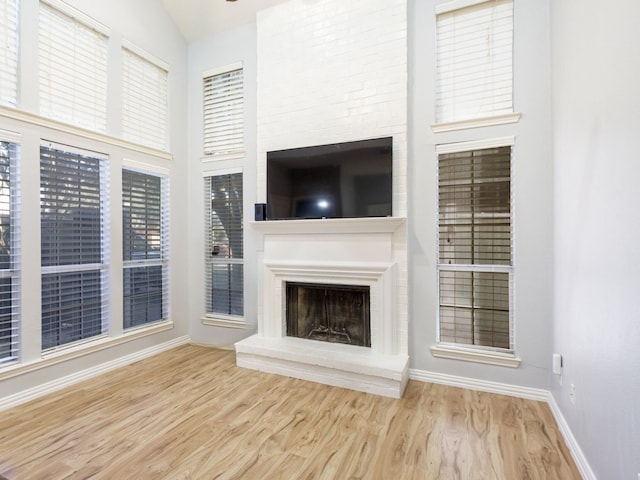 unfurnished living room featuring light hardwood / wood-style floors and a high ceiling