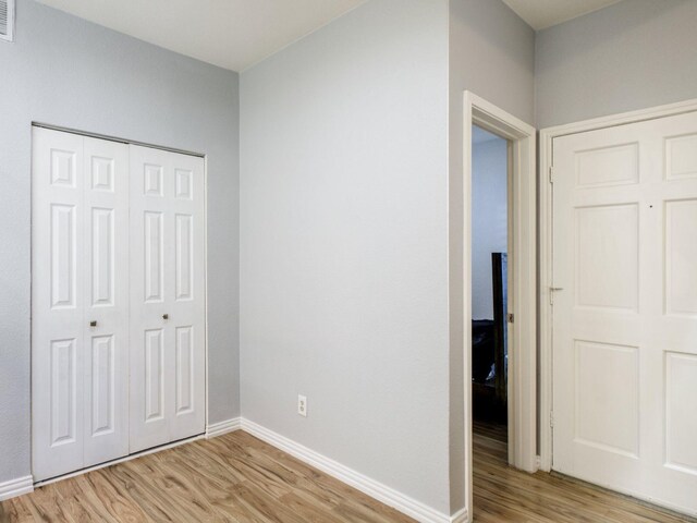 unfurnished bedroom featuring light wood-type flooring and a closet