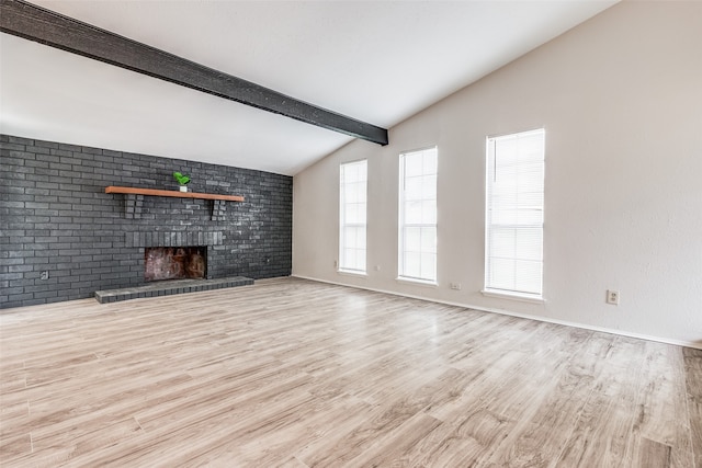 unfurnished living room with light hardwood / wood-style flooring, lofted ceiling with beams, brick wall, and a brick fireplace