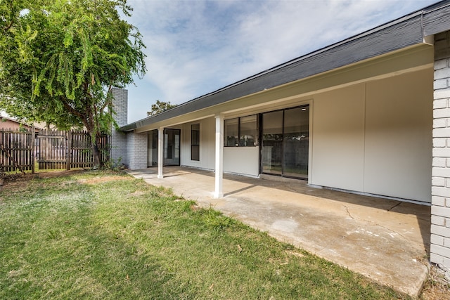 rear view of house with a patio area and a yard