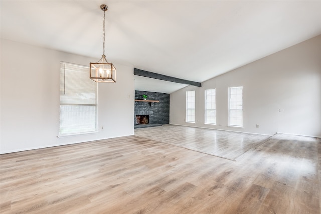 unfurnished living room with a fireplace, light wood-type flooring, and lofted ceiling with beams