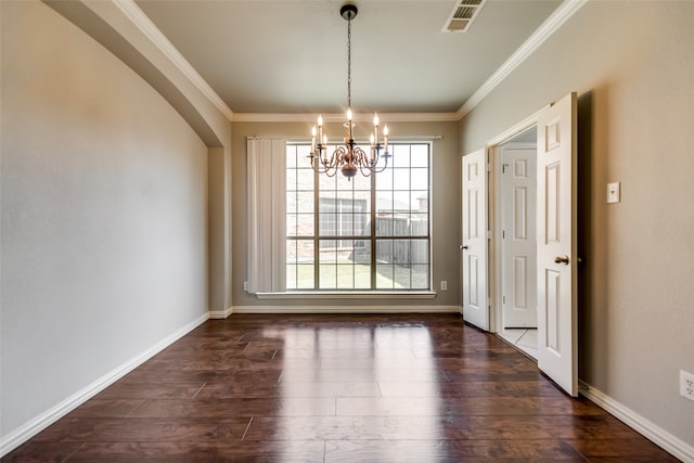 unfurnished dining area featuring dark hardwood / wood-style flooring, ornamental molding, and an inviting chandelier