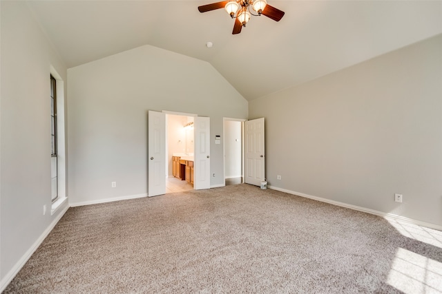 unfurnished bedroom with ensuite bathroom, high vaulted ceiling, ceiling fan, and light colored carpet