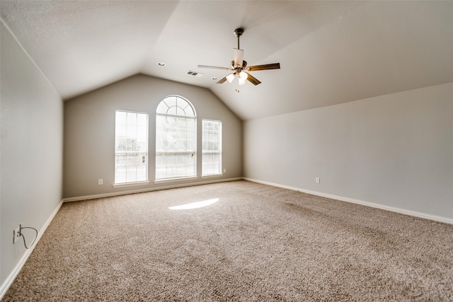 carpeted spare room with ceiling fan and lofted ceiling