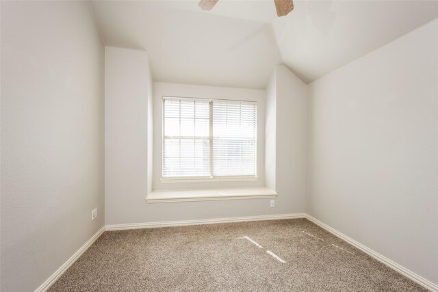 carpeted spare room featuring ceiling fan and lofted ceiling