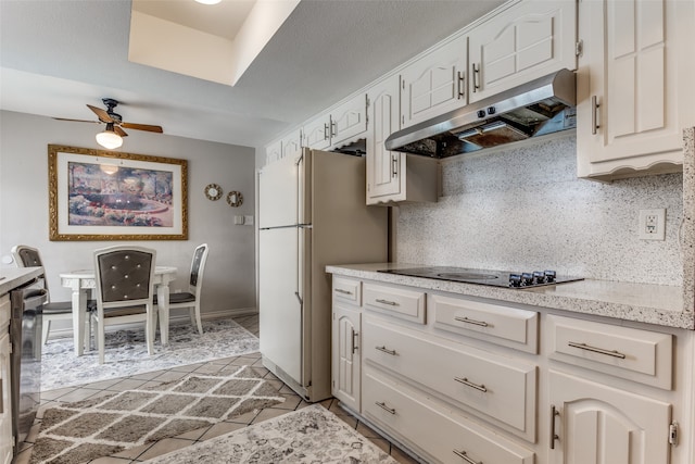 kitchen featuring white cabinets, decorative backsplash, white refrigerator, and black electric cooktop