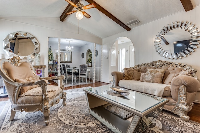 living room featuring vaulted ceiling with beams, wood-type flooring, a textured ceiling, wooden walls, and ceiling fan with notable chandelier