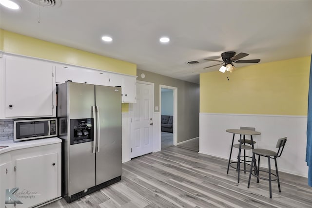 kitchen with white cabinetry, ceiling fan, stainless steel appliances, tasteful backsplash, and light hardwood / wood-style flooring