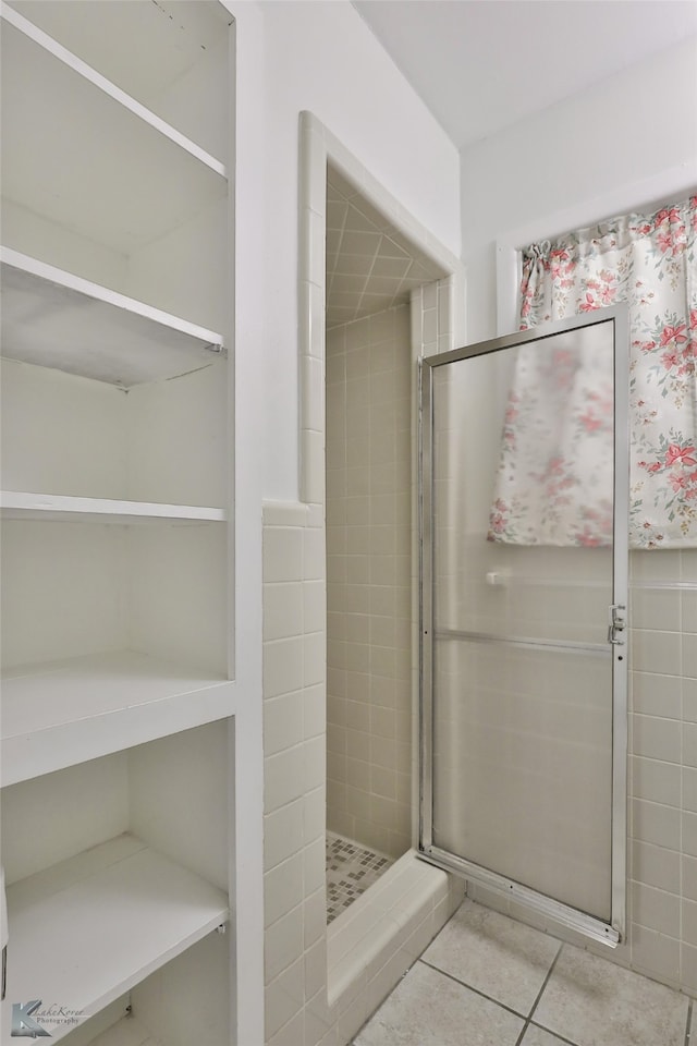 bathroom featuring a tile shower and tile patterned flooring