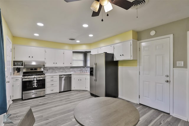 kitchen featuring appliances with stainless steel finishes, ceiling fan, sink, light hardwood / wood-style flooring, and white cabinets