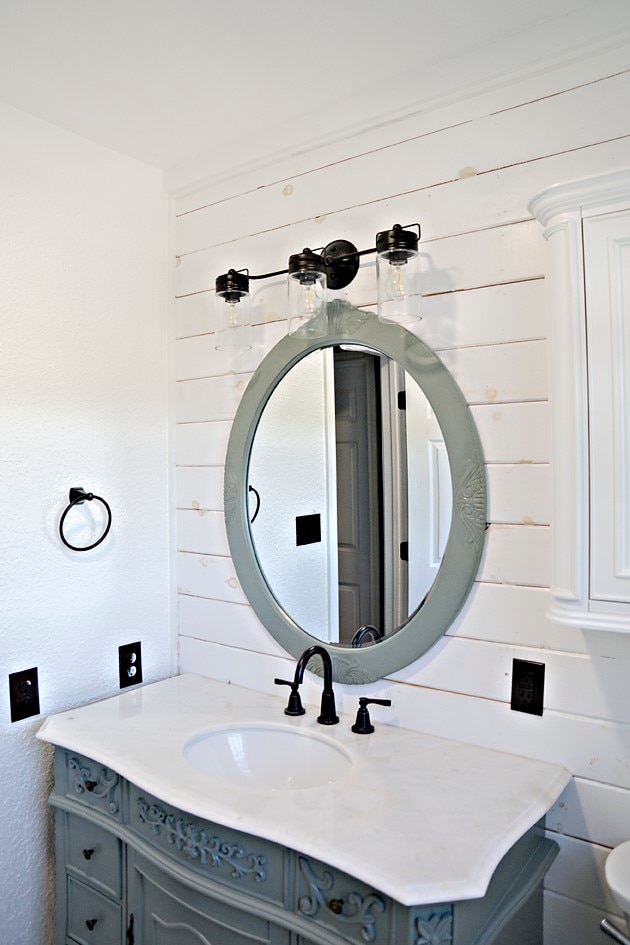 bathroom featuring vanity and wood walls