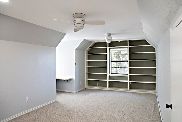 bonus room featuring a textured ceiling, carpet floors, ceiling fan, and lofted ceiling