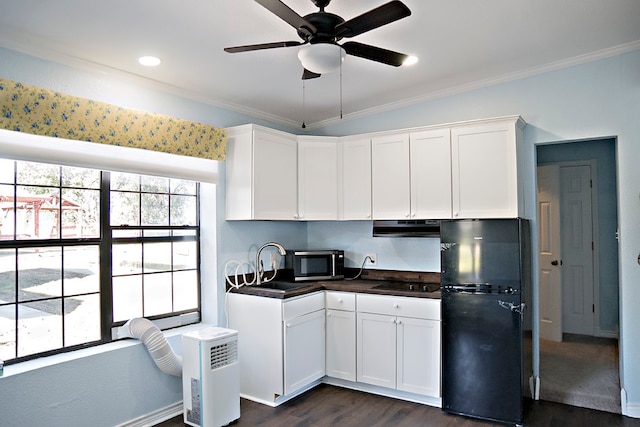 kitchen featuring dark wood-type flooring, black appliances, white cabinets, crown molding, and range hood