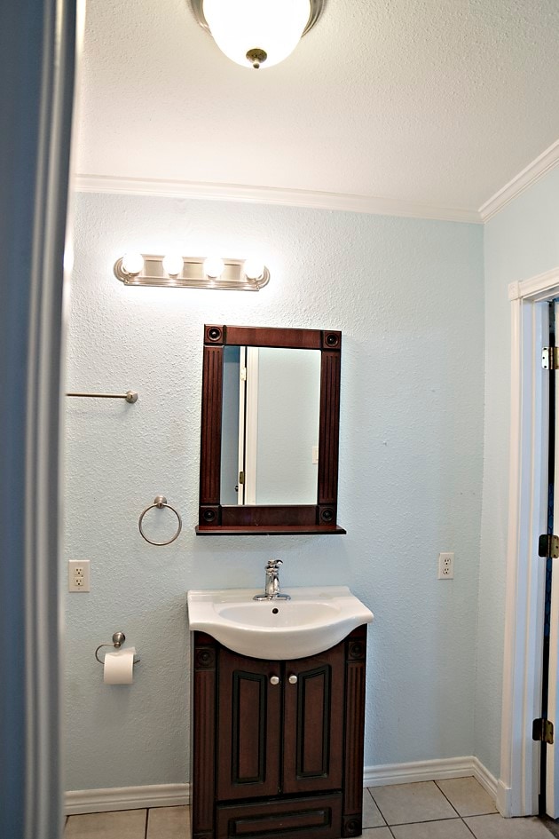 bathroom featuring tile patterned floors, crown molding, and vanity