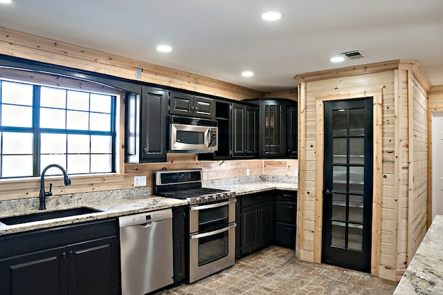 kitchen featuring light stone countertops, sink, and appliances with stainless steel finishes