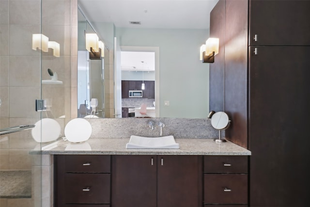 bathroom with decorative backsplash, vanity, and walk in shower