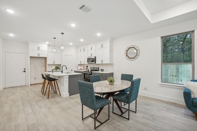 dining room featuring recessed lighting, baseboards, visible vents, and light wood finished floors