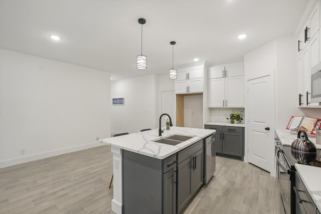 kitchen with sink, gray cabinets, a kitchen island with sink, white cabinets, and appliances with stainless steel finishes