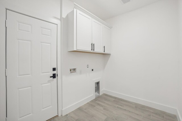 clothes washing area featuring hookup for a gas dryer, hookup for an electric dryer, washer hookup, baseboards, and cabinet space