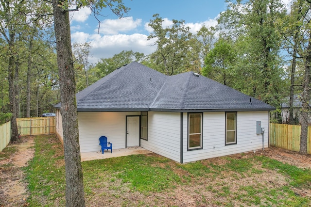 rear view of property featuring a lawn and a patio area