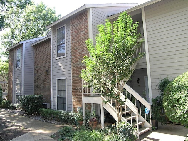 1200 Riverchase Ln Unit 226, Arlington, TX 76011 - view of side of property with stairway, brick siding, and central AC