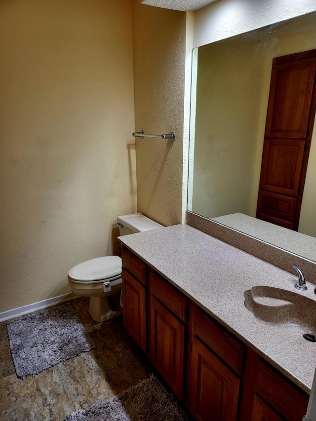 1200 Riverchase Ln Unit 226, Arlington, TX 76011 - half bathroom with vanity, toilet, a textured wall, and baseboards