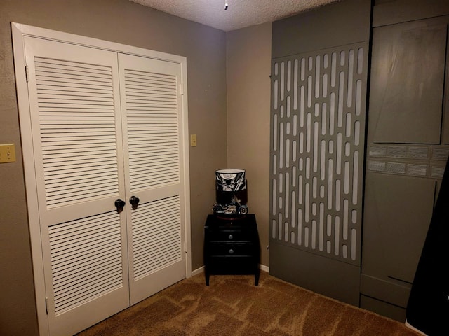 unfurnished bedroom featuring carpet flooring, a textured ceiling, and a closet