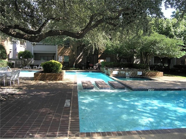 view of swimming pool featuring a jacuzzi