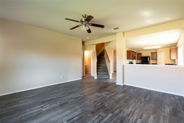 unfurnished living room featuring ceiling fan and dark wood-type flooring