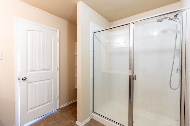 bathroom featuring tile patterned floors and a shower with shower door